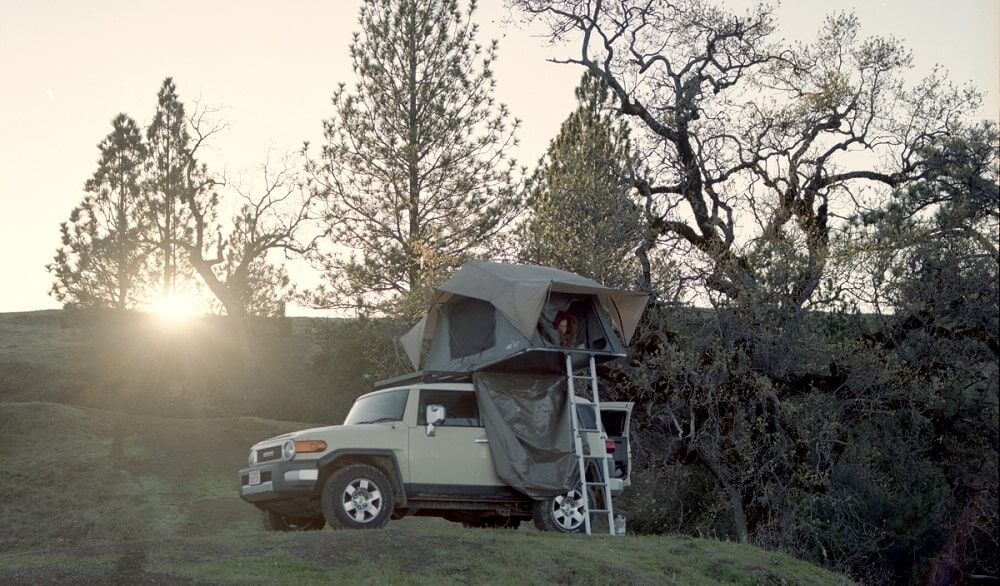 Ein Zelt ist auf dem Dach eines Geländefahrzeugs befestigt und einsatzbereit