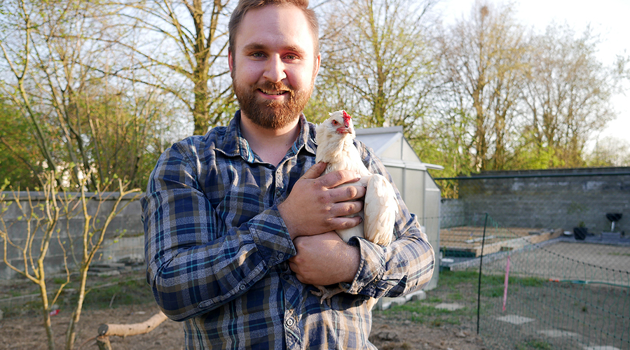 a man with a chicken in his arms