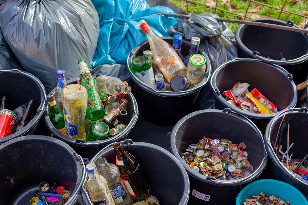 Flaschen und anderer Müll sortiert in mehrere Eimer.