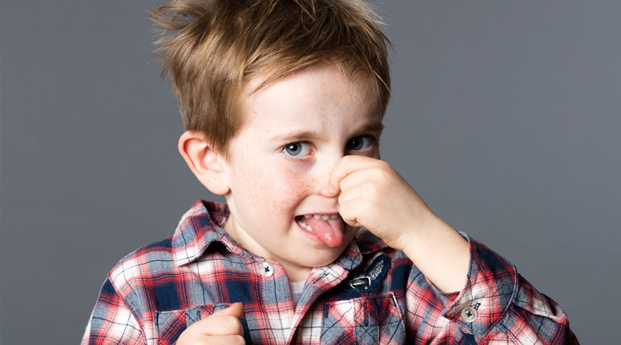 A boy is holding his nose
